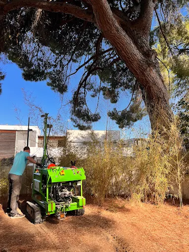 Homme effectuant un sondage geotechnique avec une foreuse verte