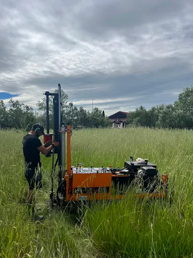 Homme utilisant une machine de forage dans un champ